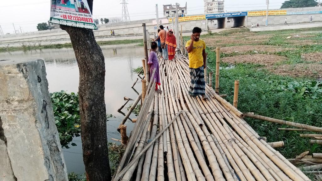 রাজধানীর মানুষ পার  হচ্ছে বাঁশের সাঁকোয়